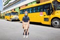 Back to school. Little girl from elementary school outdoor near yellow bus. Kid going learn new things 1th september Royalty Free Stock Photo