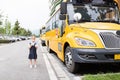 Back to school. Little girl from elementary school outdoor near yellow bus. Kid going learn new things 1th september Royalty Free Stock Photo