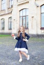 Back to school. A little girl of preschool age stands with an apple on her first day at school or kindergarten. little schoolgirl