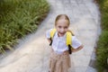 Back to school. Little girl with yellow backpack from elementary school outdoor. Kid going learn new things 1th Royalty Free Stock Photo