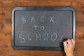 Back to school message on blackboard with chalk in hand Royalty Free Stock Photo