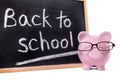 Back to school message on blackboard, piggy bank, isolated on white background Royalty Free Stock Photo