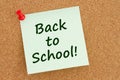 Back to School message green sticky note on cork bulletin board Royalty Free Stock Photo