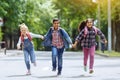 Back to school. Mixed Racial Group of happy elementary school students with backpacks running holding hands outdoors