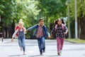 Back to school. Mixed Racial Group of happy elementary school students with backpacks running holding hands outdoors Royalty Free Stock Photo