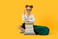 Back To School. Nerdy Little Schoolgirl Sitting With Books And Raising Hand Royalty Free Stock Photo