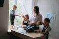 Back to school in new normal. Mother helps schoolchildren pack their backpacks for school and gives them face masks and sanitizers