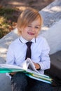 Back to school. Outdoor portrait of Schoolboy read a book, outdoor. Cute kid wear stylish outfit