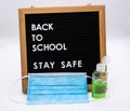Back to school on pegboard with stay safe message antibacterial gel and childrens face mask