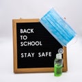 Back to school on pegboard with stay safe message antibacterial gel and childrens face mask