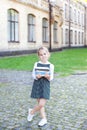 Back to school. Portrait of a schoolgirl with books, textbooks on the background of the school. Education concept. Preschool educa Royalty Free Stock Photo
