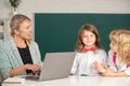 Back to school. School pupil with teacher learning at laptop computer, studying with online education e-learning in Royalty Free Stock Photo