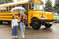 Back to school. Pupils of primary school near school bus. Happy children ready to study. little girl with mom going to Royalty Free Stock Photo