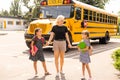 Back to school. Pupils of primary school near school bus. Happy children ready to study. little girls with mom going to Royalty Free Stock Photo