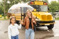 Back to school. Pupils of primary school near school bus. Happy children ready to study. little girl with mom going to Royalty Free Stock Photo