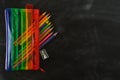 Back to school. Rainbow pencil case with school supplies for student. Black background. Copy space