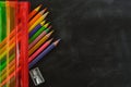 Back to school. Rainbow pencil case with school supplies for student. Black background. Copy space