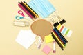 Back to school, school supplies with medical face mask and chat cardboard bubble on a yellow background. Protection of schoolchild