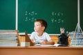 Back to school. A schoolboy is reading a book while sitting at the table for the first time at school on the background of the Royalty Free Stock Photo