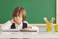 Back to school. A schoolboy is reading a book while sitting at the table for the first time at school on the background Royalty Free Stock Photo