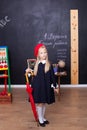 Back to school! Schoolgirl in the classroom with an umbrella. Royalty Free Stock Photo