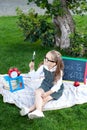 Back to school. Schoolgirl holds a magnifying glass. Girl looking through a magnifier on the street against the background of the