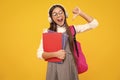 Back to school. Schoolgirl student in headphones with school bag backpack hold book on isolated studio background Royalty Free Stock Photo