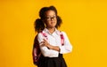 Serious Black School Girl Crossing Hands Posing Over Yellow Background Royalty Free Stock Photo