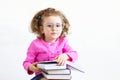 Back to school. serious, brooding, cute smart little girl in funny big glasses reading a stack of paper books Royalty Free Stock Photo