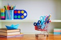 Back to School Shopping Cart with Supplies on Wooden Table. Royalty Free Stock Photo
