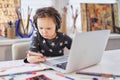 Back to school: small kid using a laptop and smartphone Royalty Free Stock Photo