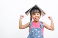 Back to school. Smiling little girl carrying a backpack holding books on her head looking at the camera on a white background with Royalty Free Stock Photo