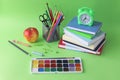 Back to school, stationery, alarm clock, stack of books, apple on bright background Royalty Free Stock Photo