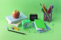 Back to school, stationery, alarm clock, stack of books, apple on bright background Royalty Free Stock Photo