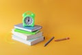 Back to school, stationery, alarm clock, stack of books on bright background Royalty Free Stock Photo