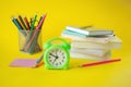 Back to school, stationery, alarm clock, stack of books and colored pencils Royalty Free Stock Photo