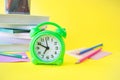 Back to school, stationery, alarm clock, stack of books and colored pencils Royalty Free Stock Photo