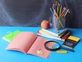 Back to school, stationery, magnifying glass, stack of books, apple on the table, home learning concept