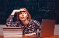 Back to school. Student working on a laptop on some stairs on campus preparing for an exam. Angry screaming - negative Royalty Free Stock Photo