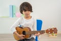 Back to school and summer course. Little children play guitar in kindergarten