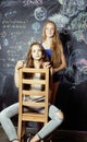 Back to school after summer vacations, two teen girls in classroom with blackboard painted together Royalty Free Stock Photo