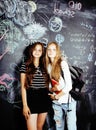 Back to school after summer vacations, two teen real girls in classroom with blackboard painted together, lifestyle Royalty Free Stock Photo