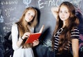 Back to school after summer vacations, two teen real girls in classroom with blackboard painted together Royalty Free Stock Photo