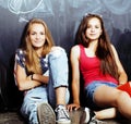 Back to school after summer vacations, two teen real girls in classroom with blackboard painted together, lifestyle real Royalty Free Stock Photo