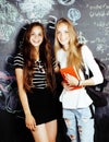 Back to school after summer vacations, two teen real girls in classroom with blackboard painted together, lifestyle Royalty Free Stock Photo