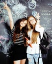 Back to school after summer vacations, two teen real girls in classroom with blackboard painted together, lifestyle Royalty Free Stock Photo