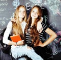 back to school after summer vacations, two teen real girls in classroom with blackboard painted together, lifestyle real Royalty Free Stock Photo