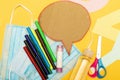 Back to school, school supplies and chat cardboard bubble on a yellow background. Protection of schoolchildren and students from t