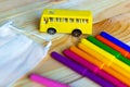 Back to school - supplies colored pencils and toy yellow school bus on the table. Royalty Free Stock Photo