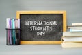 Back to school supplies. Students Day. Books, pens, colorful chalks and blackboard on gray background. Copy space. Royalty Free Stock Photo